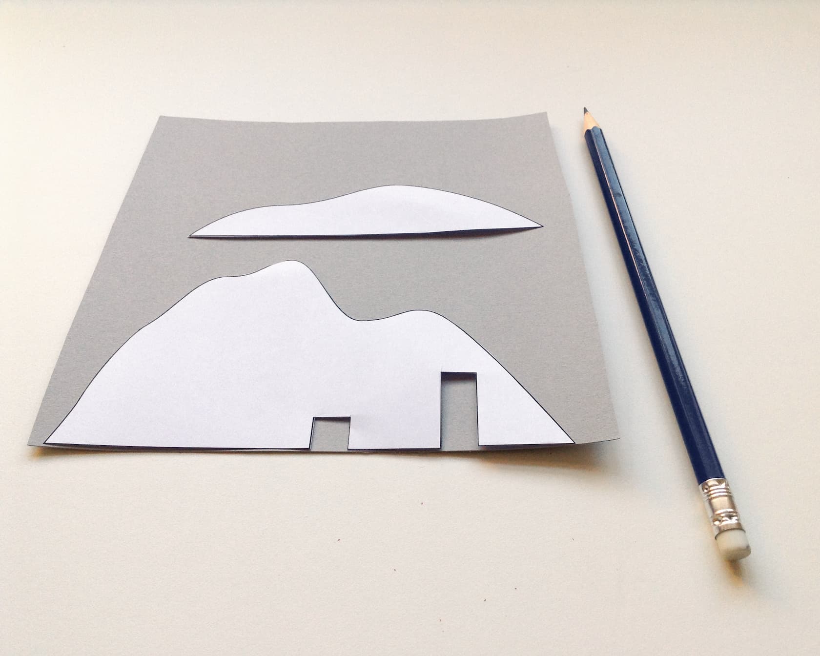 Use the mountain shapes as a stencil onto the grey card