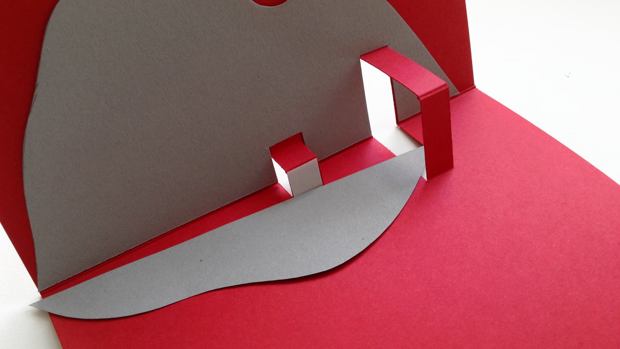 Stick the smaller mountain shape onto the smaller pop-out support