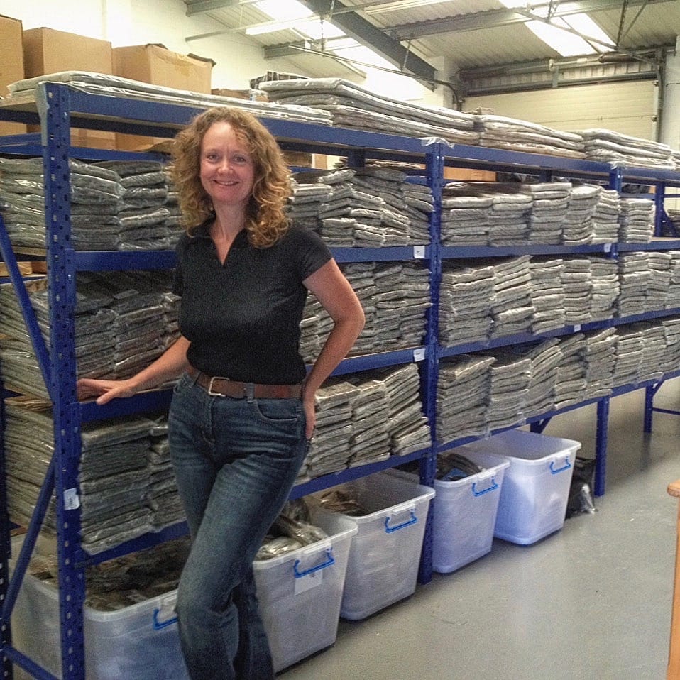 Sally Phillips of Chimney Sheep Ltd., standing next to racks of Herdwick fleece