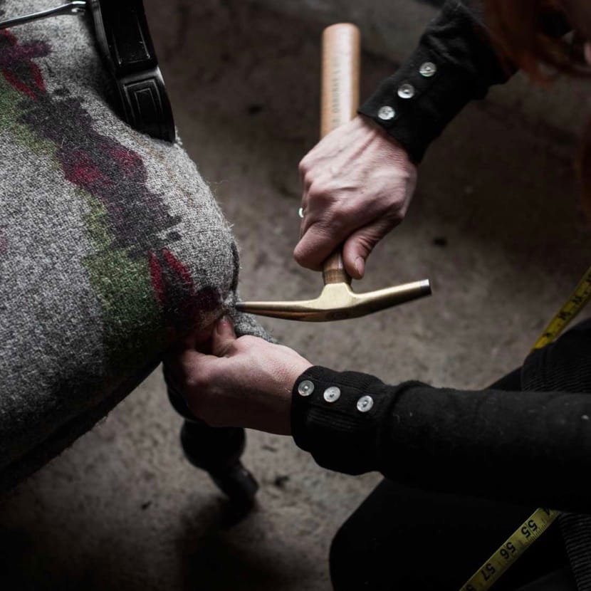 Working with Herdwick fleece on some upholstery with a hammer