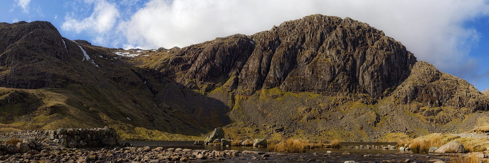 A view of the cliffs of Pavey Ark and Harrison Stickle from the shore of Stickle Tarn. Photo by nagualdesign (CC BY-SA 4.0)