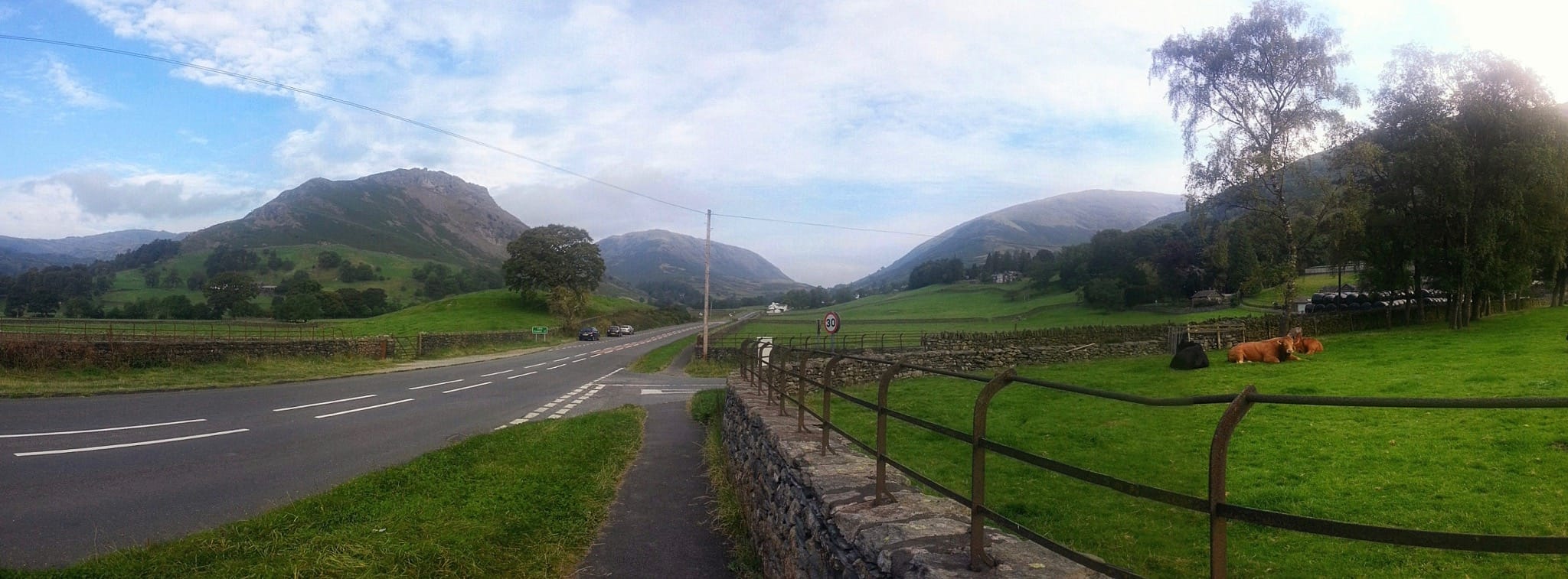 A panoramic view north of Grasmere village from near the A591 trunk road. Helm crag on the left, Steel Fell in the centre, Seat Sandal on the right