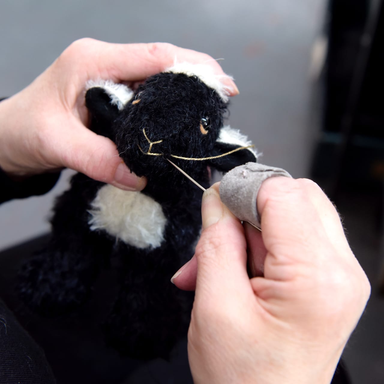 Merrythought worker putting the final touches together on the face of My Herdy Lamb