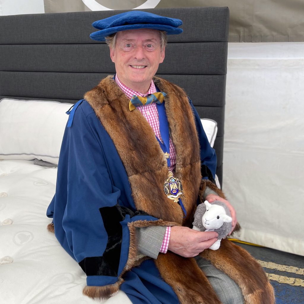 Lord Mayor at the London Sheep Drive sitting on a Herdysleep mattress with a Little Herdy Soft Toy