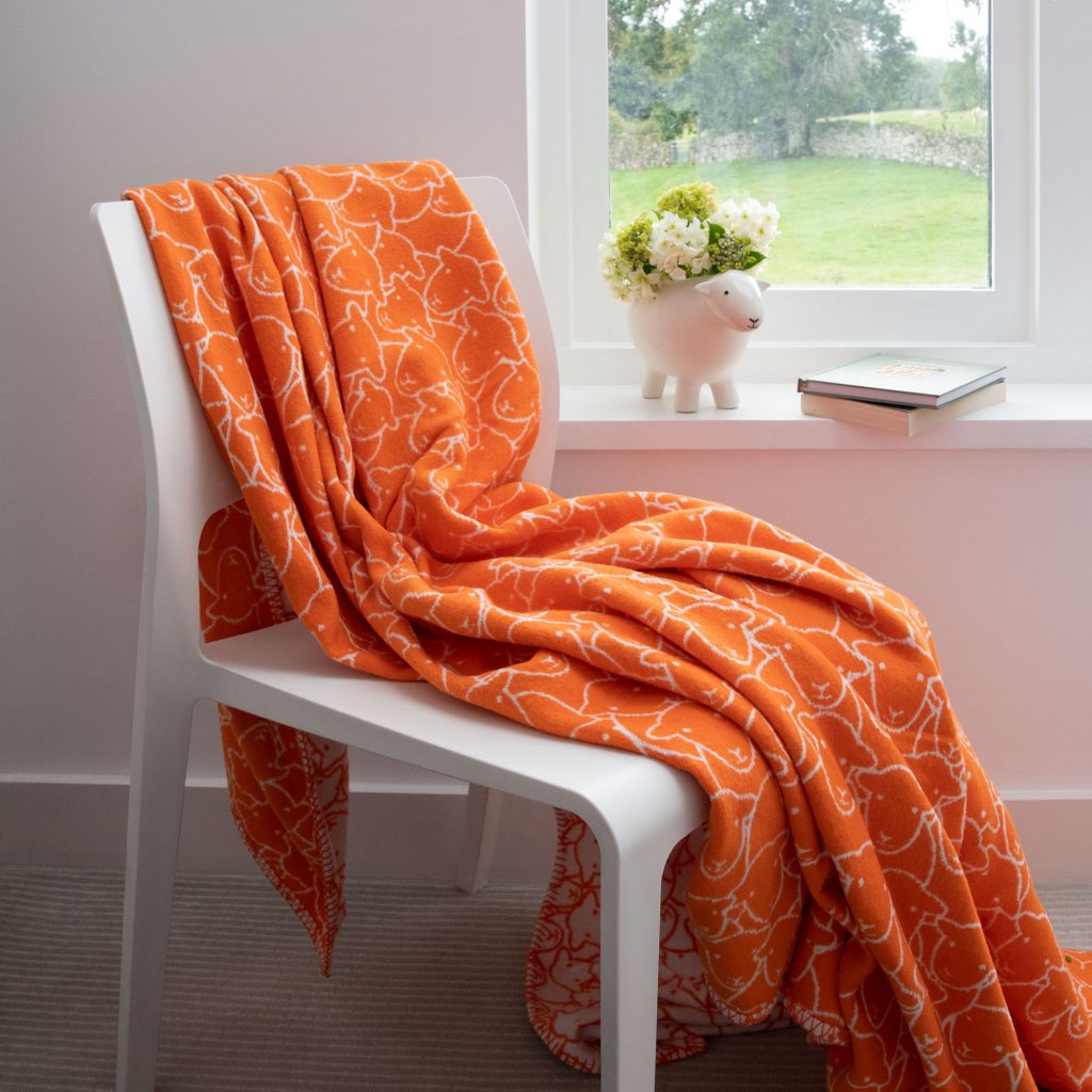 Herdy recycled cotton throw in orange: Print shows a flock of herdy's